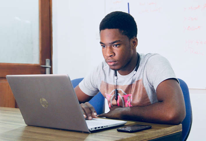 un jeune qui est en train de regarder sur un ordinateur